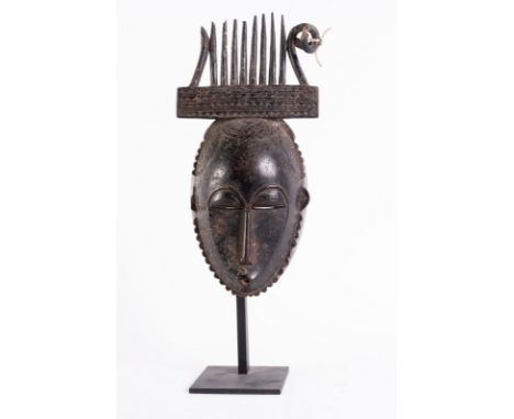 African art Portrait mask, YaureIvory Coast. . Cm 33,00. A fine dark patina wooden mask with comb headdress. An idealized fem