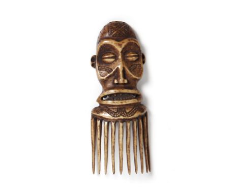 African art Pwo ivory comb, ChokweAngola. . Cm 14,50. A large ivory comb with brown patina carved in the shape of a female fa