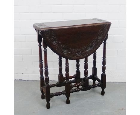 An oak  foliate carved gate leg table, 70 x 66cm