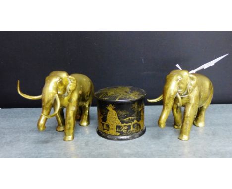 A Japanese black lacquered papier mache trinket box and cover painted with gilt figures, together with a pair of brass elepha