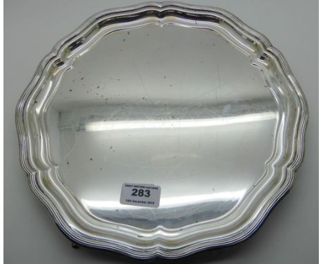 A silver salver by R &amp; W Sorley, Sheffield 1933, of circular form with stepped scalloped rim on three outswept feet, 29.5