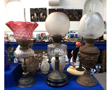 Three assorted oil lamps, one with cranberry shade Condition Report: etched shade lamp by Evered Birmingham.  Lamp with ball 