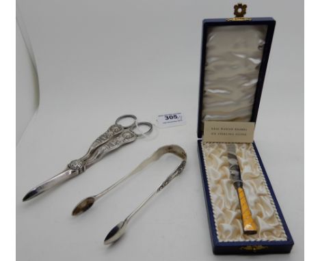 A lot comprising a pair of silver sugar tongs, EP grape scissors and a cased Danish silver and enamelled handled butter knife