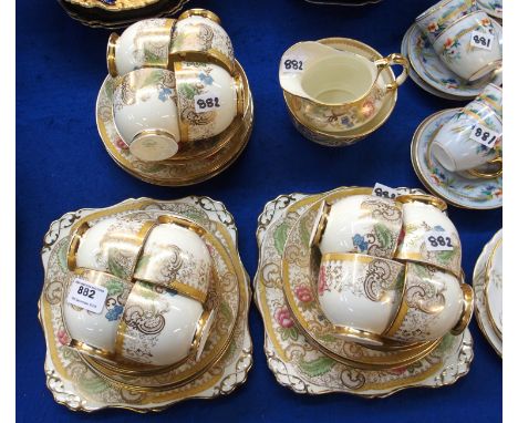 A Plant Tuscan teaset, the cream ground with gilt and coloured decoration comprising two cake plates, twelve side plates, cup