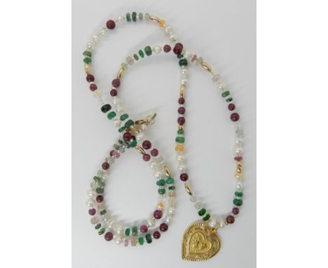 A 24k gold Chinese gold heart shaped pendant on a string of pearl emerald, ruby and other gemstone beads with gold bead space