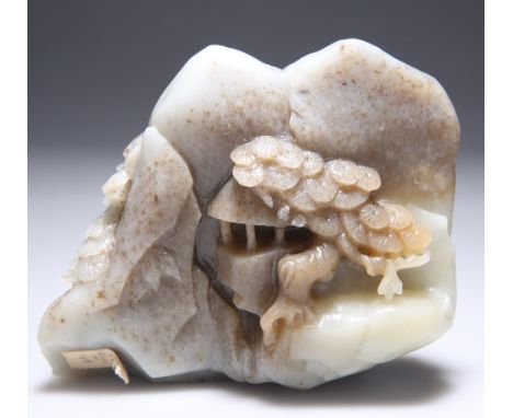 A CHINESE JADE BOULDER CARVING, PROBABLY QING DYNASTY, carved with a figure, pagoda and prunus blossom. 13.5cm wide