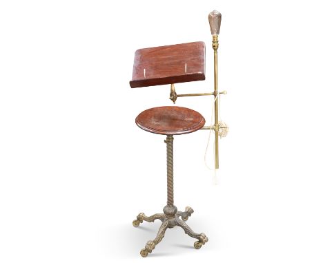 A LATE VICTORIAN BRASS AND MAHOGANY READING STAND, with adjustable reading slope and light fitting, the twisted stem continui