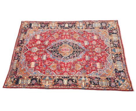 A LARGE PERSIAN KASHAN CARPET, hand-knotted, the raspberry field with large scalloped dark blue medallion with pale blue edge