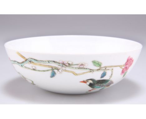 A CHINESE FAMILLE ROSE BOWL, enamel painted with a bird perched on blossoming boughs, bears a six-character mark within conce