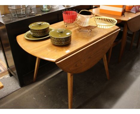 An Ercol drop leaf kitchen table, raised on square tapering supports