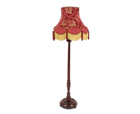 A mahogany turned column standard lamp, with floral tasselled shade