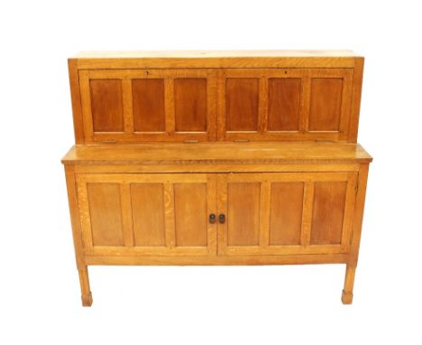 An oak Robert&nbsp; "Mouseman" Thompson drinks cabinet, enclosed by panelled doors and raised on square section supports, 130