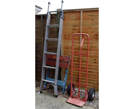 Youngman three way combination aluminium ladder, red finished metal sack barrow, and a work bench   Condition: 