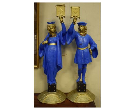 Pair of painted spelter figural candlesticks, each modelled as a robed figure holding aloft a socket displaying the four play