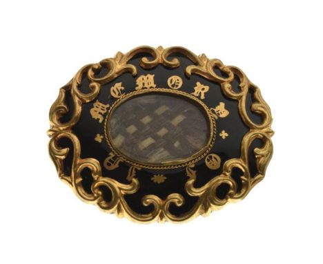 19th Century yellow metal oval mourning brooch having enamel decoration with script 'In Memory', and with oval hair panel to 