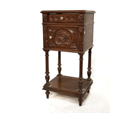 French carved oak pot cupboard, the moulded square top over carved frieze drawer and cupboard with Romayne style circular por