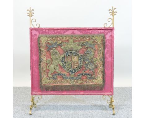 A 19th century brass, silk and stumpwork fire screen, decorated with an heraldic crest, 69cm