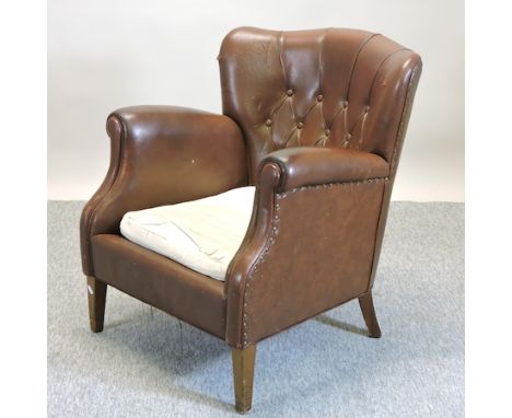 A 1920's brown leather upholstered button back armchair 