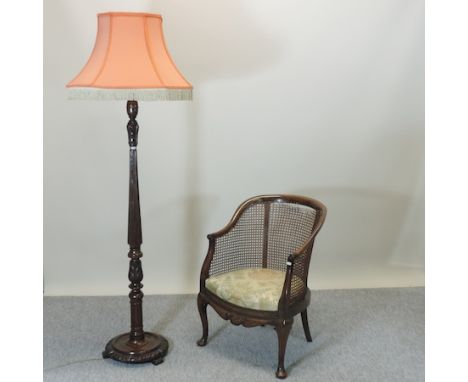 An early 20th century turned wooden standard lamp and shade, together with a 1920's bergere chair