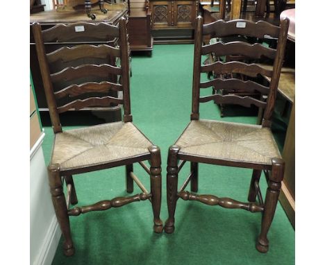 A set of six rush seated ladder back dining chairs 