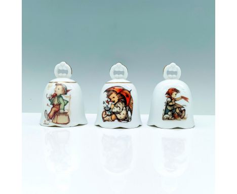 A set of three white bells decorated with gold-colored borders that depict the art pieces of wandering traveler, umbrella gir