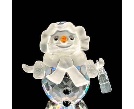 Whimsical faceted crystal figurine modeled as a smiling snow woman holding a handbag. Black buttons, orange nose. Satin cryst