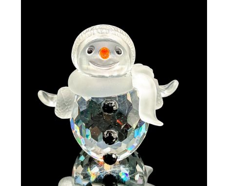 Whimsical faceted crystal figurine modeled as a smiling snowman with his arms wide. Black buttons, orange nose. Satin crystal