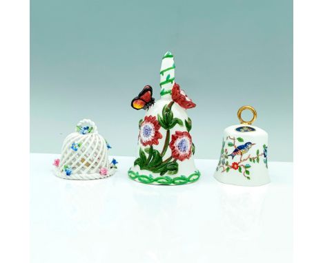 A set of three white bells that are decorated or painted with a floral design along with some animals on the items. The small