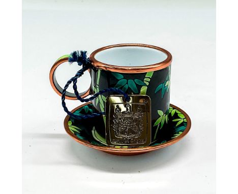 Hand painted enamel over porcelain with black background and green bamboo design with copper toned edges on cup and saucer. C
