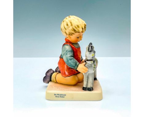 Horse Trainer HUM423 hand painted in matte finish modeled as a young boy playing with his rocking horse. M. I. Hummel impress