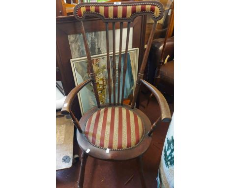 An early 20th Century stained wood framed high stick back elbow chair with shaped top rail and studded upholstery - sold with