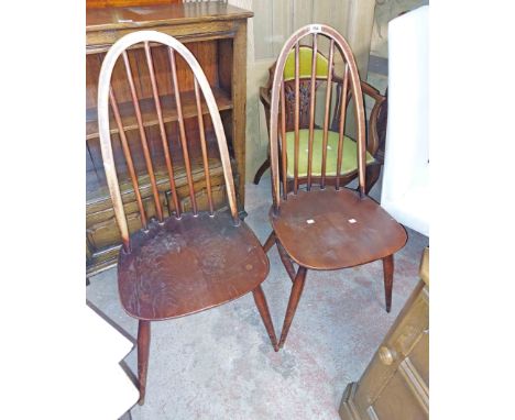 A pair of Ercol dark elm hoop stick back dining chairs with moulded seats