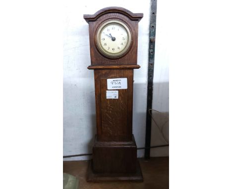 A vintage miniature oak longcase clock with simple mechanical timepiece movement