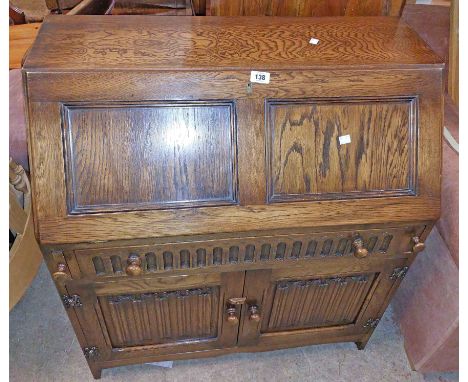 An 84cm vintage oak bureau with part fitted interior over single long frieze drawer and double cupboard under
