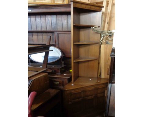A 68cm Ercol dark elm three shelf corner unit with cupboard to base, set on plinth base - 1.98m high
