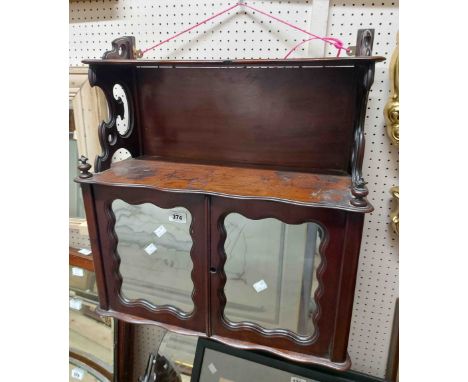 A 58cm late Victorian mahogany wall mounted cabinet with serpentine edges, raised shelf with pierced bracket supports and dou