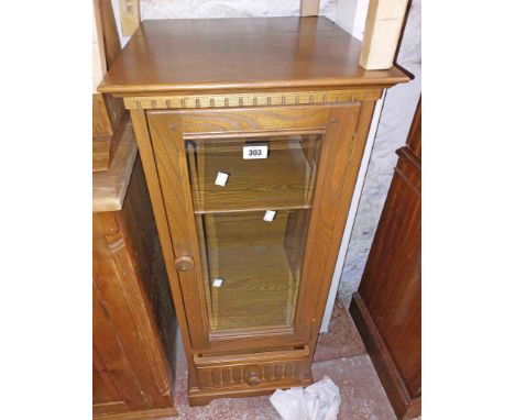 A 40cm Ercol dark elm hifi cabinet with shelves enclosed by a glazed panel door