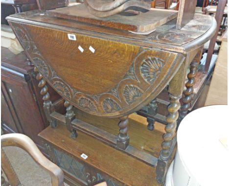 An 83cm vintage carved oak gateleg table, set on barley twist supports
