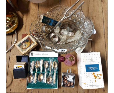 A glass bowl containing collectable items including vintage playing cards, napkin rings, a cased set of teaspoons, ceramic th