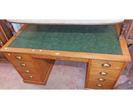 A 1.51m vintage Simpole, Liverpool oak kneehole desk with green leather inset top and eight pedestal drawers, set on plinth b