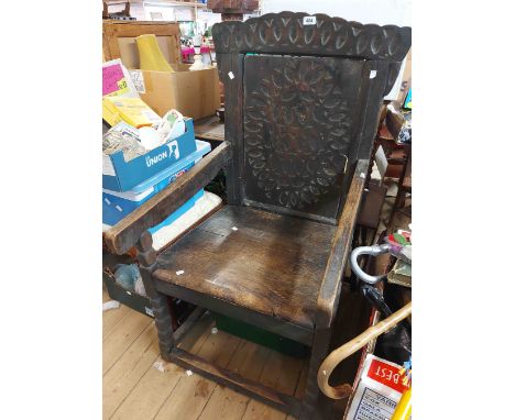 An antique oak Wainscot chair with simple carved repeat pattern decoration to the top rail and back panel, solid seat and bob