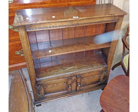 A 84cm reproduction oak open bookcase in the antique style with open shelf and double cupboard under, set on block feet