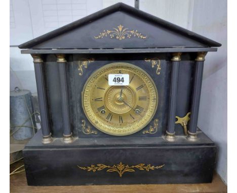 A late Victorian black slate cased mantel clock of architectural design with Ansonia gong striking movement
