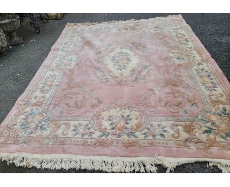 A Chinese washed wool carpet with floral motifs within a decorated border on pale pink ground - 3.1m X 2.4m