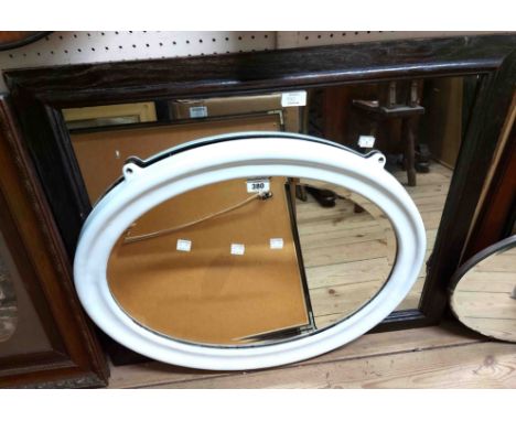 A vintage white enamelled metal framed bevelled oval wall mirror - sold with a stained oak framed wall mirror