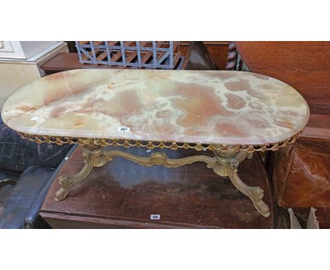 A 1.12m vintage ornate brass framed coffee table with moulded oval onyx top, set on flanking bulbous supports