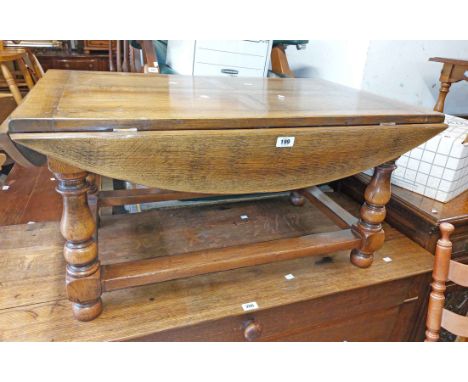 A 93cm vintage polished oak drop-leaf coffee table, set on turned supports