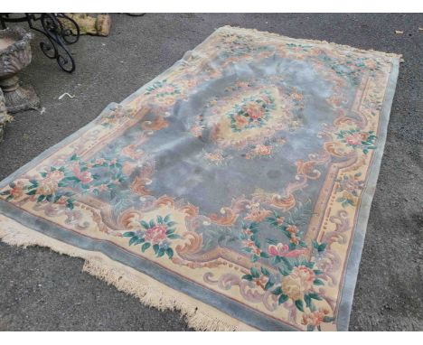 A Chinese washed wool carpet with floral motifs within a decorated border on pale jade ground - 2.9m X 1.8m
