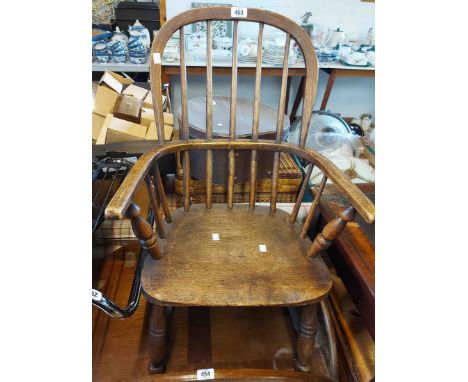 An old hoop stick back Windsor child's elbow chair with moulded solid elm seat, set on ring turned supports