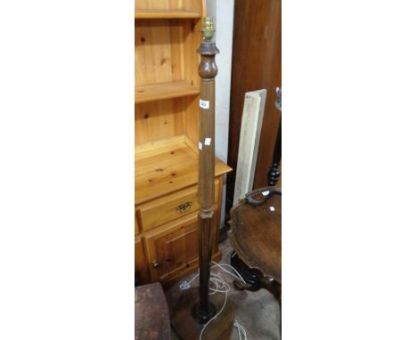 A vintage stained wood standard lamp with faceted pillar and hexagonal base, set on bun feet